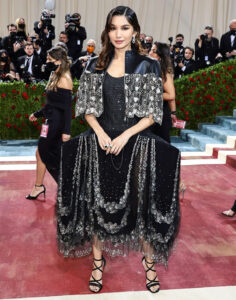 A photo of Gemma Chan at the MET Gala, she is wearing a black dress bedazzled with different metals. Daniel Martin did her makeup for the event