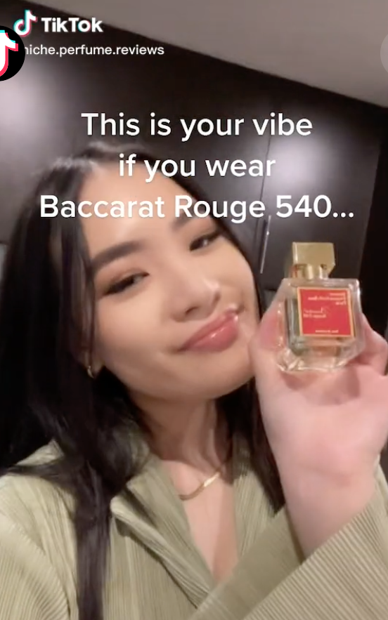 TikToker @niche.perfume.reviews holding the Baccarat Rouge 540